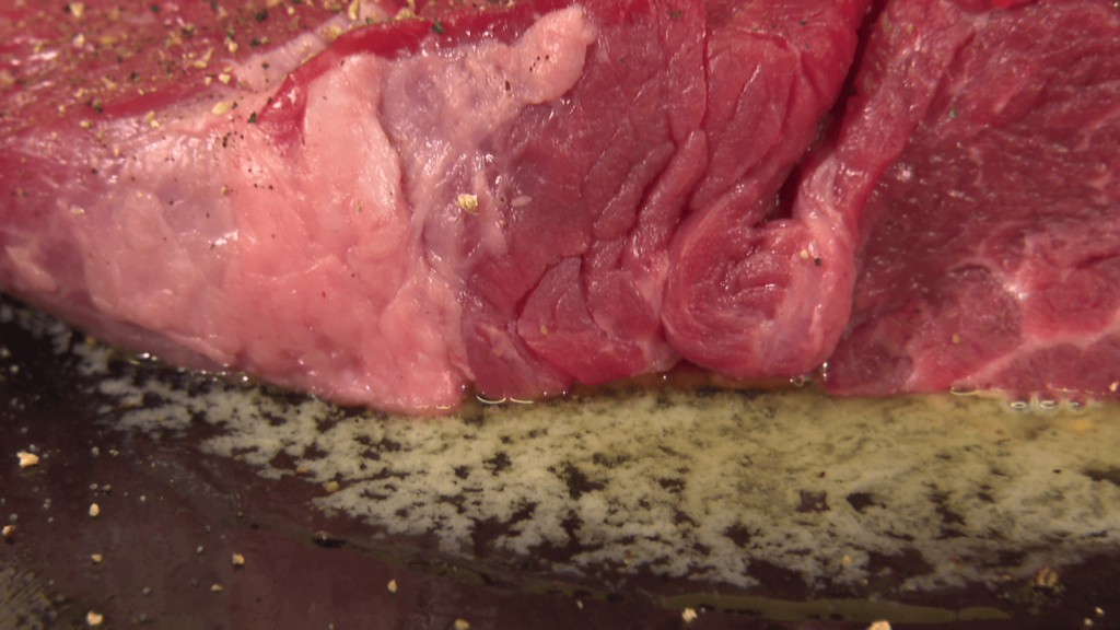 肉グルメ、切り株ステーキを焼き始めるとバターが溶け出していく